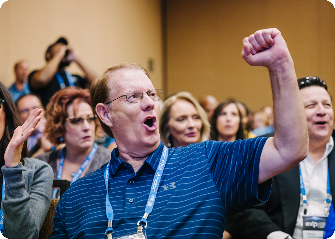 A man enthusiastically raising his fist in the air during a conference.