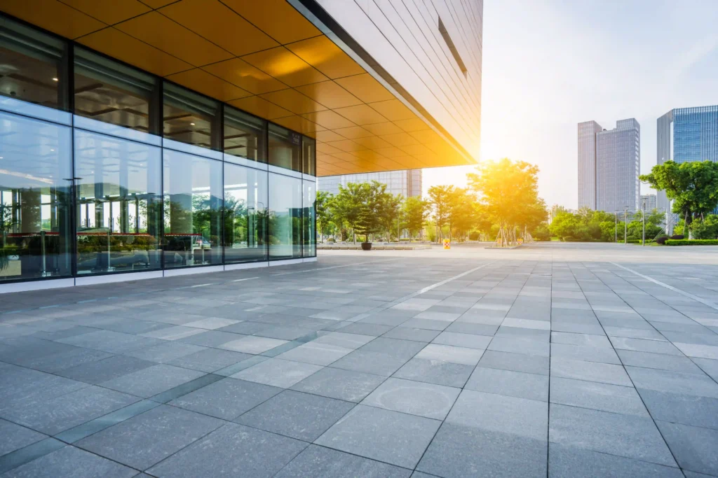 A modern commercial building with glass windows and a wide open courtyard.